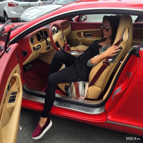 Kobieta w czerwonym sportowym samochodzie.