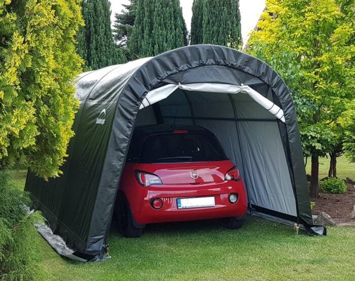 Namiot garażowy ustawiony na zielonym trawniku. Namiot to doskonała alternatywa dla garażu lub w ...